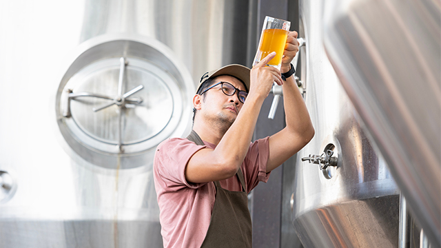 Asian_worker_inspecting_a_beer.jpg